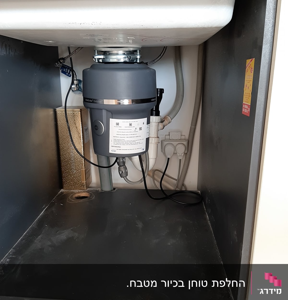 מתקן טוחן אשפה מתחת לכיור במטבח
